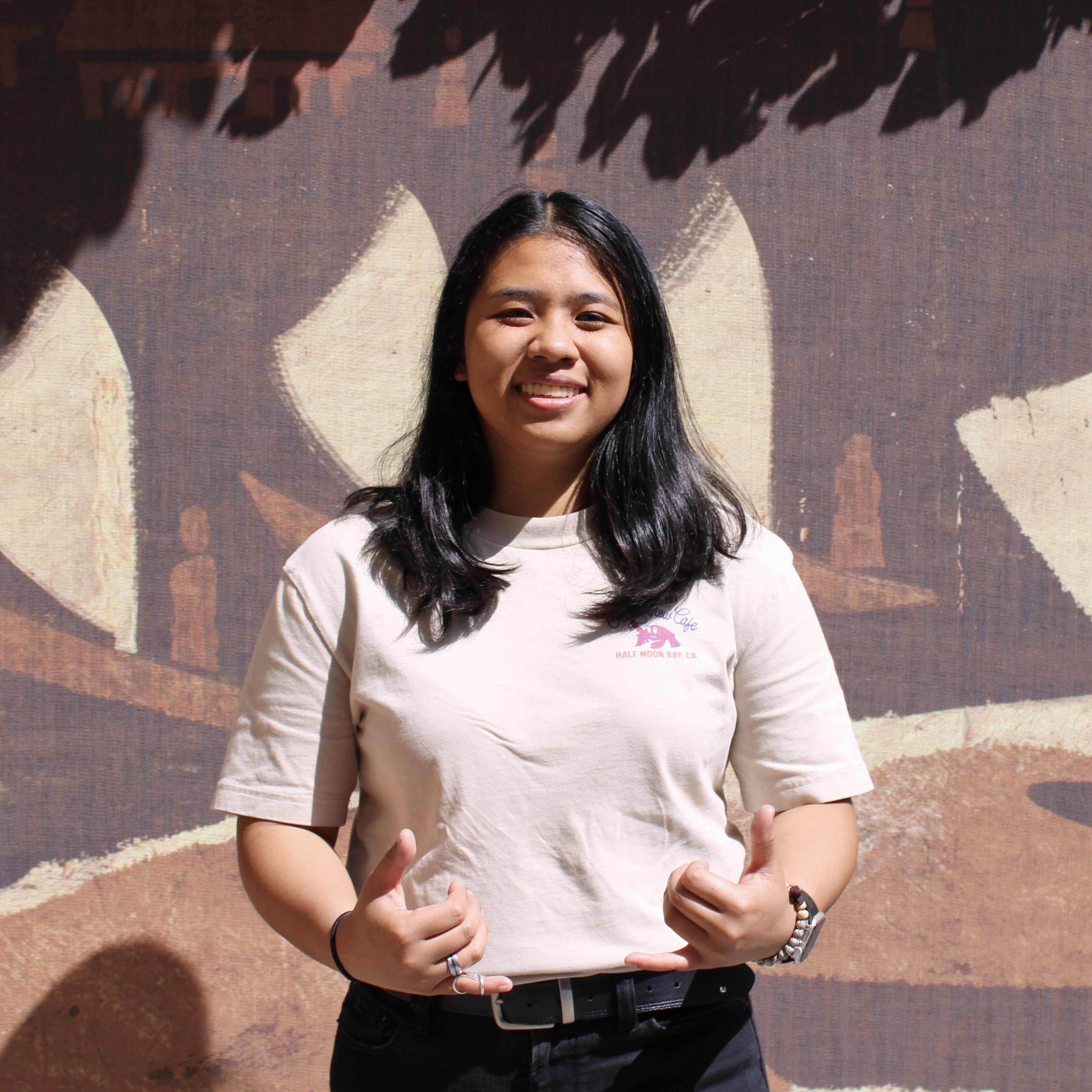 Alyssa posing in front of a brown mural